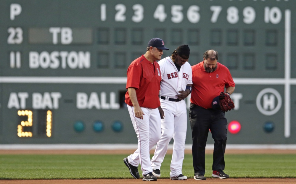 Red Sox left fielder Hanley Ramirez is helped from the field by manager John Farrell, left, and trainer Rick Jameyson during the first inning Monday night at Fenway Park. Ramirez left the game after running into a side wall while attempting a catch.