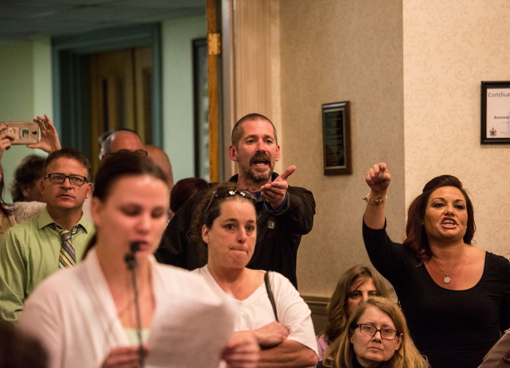Greg Blouin, left, and Mellisa Luedke, right, object to Biddeford city councilors after Mayor Alan Casavant banged his gavel to close the public comment portion of Tuesday night's emotional council meeting.
 Whitney Hayward/Staff Photographer