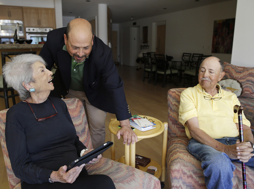 Phil Dworsky visits with his parents, Dorothy and Bill Dworsky, at their home in San Francisco. Each time Dorothy or Bill moves specific items in the house, tiny sensors make notes on a digital logbook, which Phil monitors.