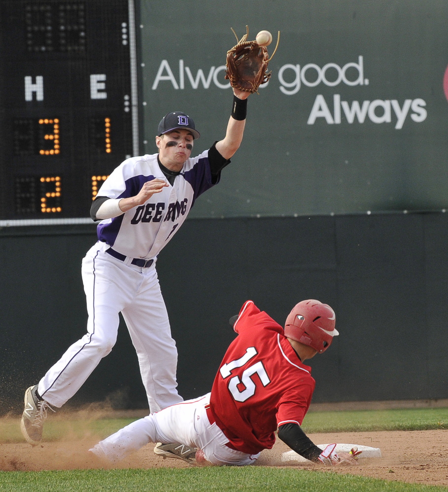 Deering’s Nick Belliveau reaches for a high throw and can’t tag out South Portland’s Sam Troiano, who later was called out when he slid past the bag.