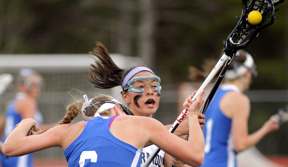 Liv Sandford of Kennebunk goes low as Lane Simsarian of Yarmouth chops at her stick in an attempt to knock the ball loose. Kennebunk is undefeated in four games and dropped the Clippers to 1-3.
