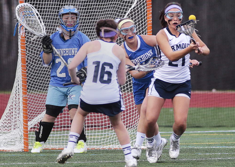 Yarmouth’s Lane Simsarian, right, attempts to control the ball Tuesday during Kennebunk’s 10-7 victory in a girls’ lacrosse game. Katie Waeldner of Yarmouth, 16, is in position as goalie Mallory Burchill and Hannah Pepin defend for the Rams.
