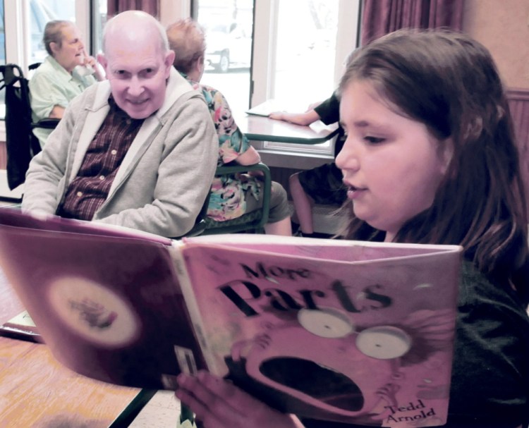 Quimby School student Lacie Sanipas reads to Somerset Rehab and Living Center resident Wilmont Robinson at the Bingham facility on Tuesday. Students are participating in "Screen Free" week where they don't use electronic devices in favor of outdoor activities and community interaction.
David Leaming/Morning Sentinel