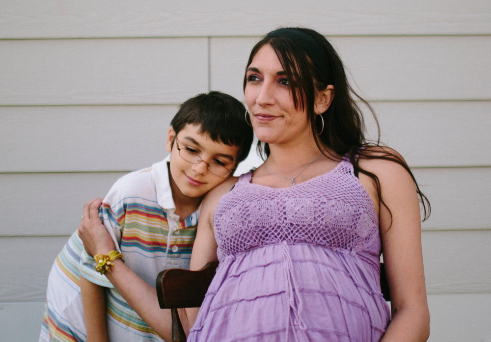 Danielle Tardy and her son Brandin Duclos, 9, outside their home in Portland on Monday. As part of the Portland Lullaby Project, Tardy wrote “Third Time’s a Charm” for her son Nikolis, who's due in July.