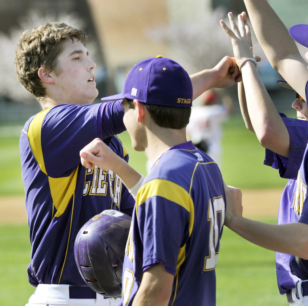 Cheverus pitcher Jensen Lapoint, left, is joined by his teammates after scoring the first run for the Stags in the victory against Scarborough.