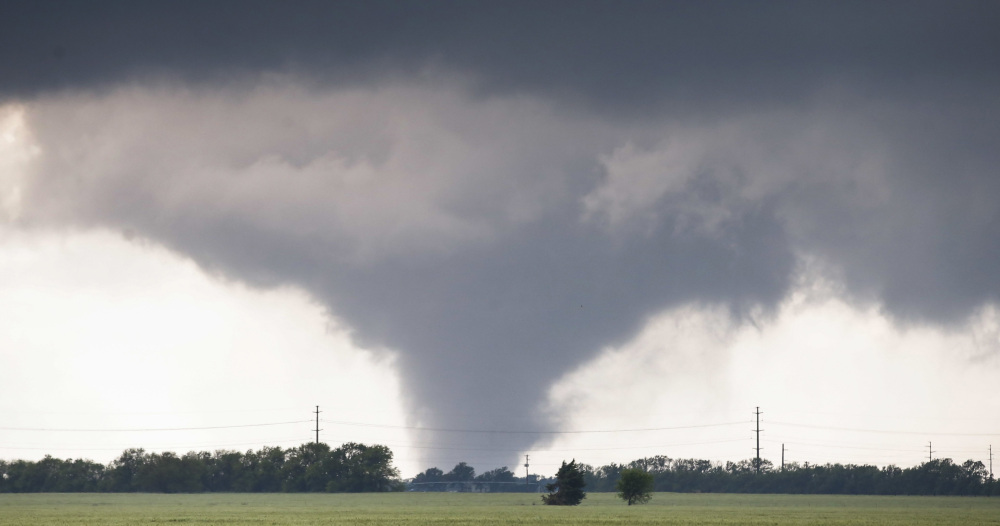 A large tornado passes to the west of the city of Halstead, Kan., on Wednesday. Storms that could produce more powerful tornadoes are forecast for Friday and Saturday.