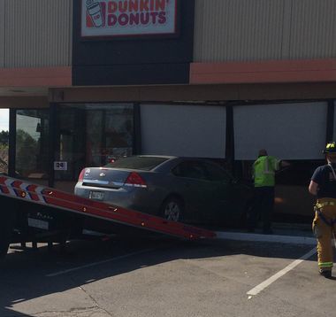 A tow truck removes a vehicle that had crashed into a Dunkin Donuts shop on South Portland's Main Street on Sunday afternoon, May 17, 2015.