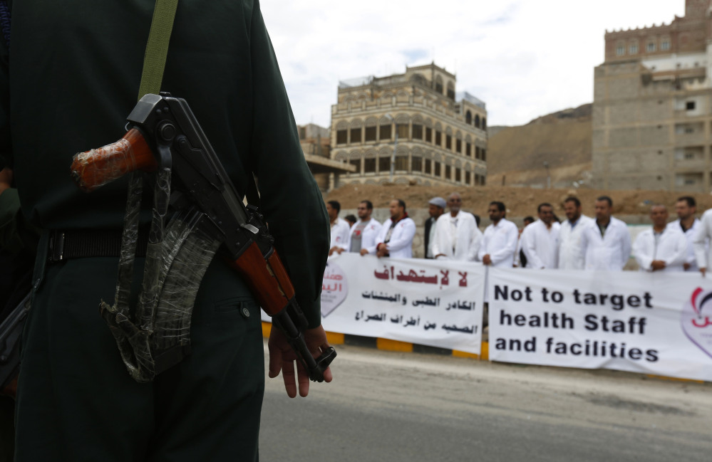 A soldier stands guard as Yemeni health workers attend a rally demanding the lifting of the blockade on Yemen, in front of the U.N. building in Sanaa, Yemen, on Thursday.
