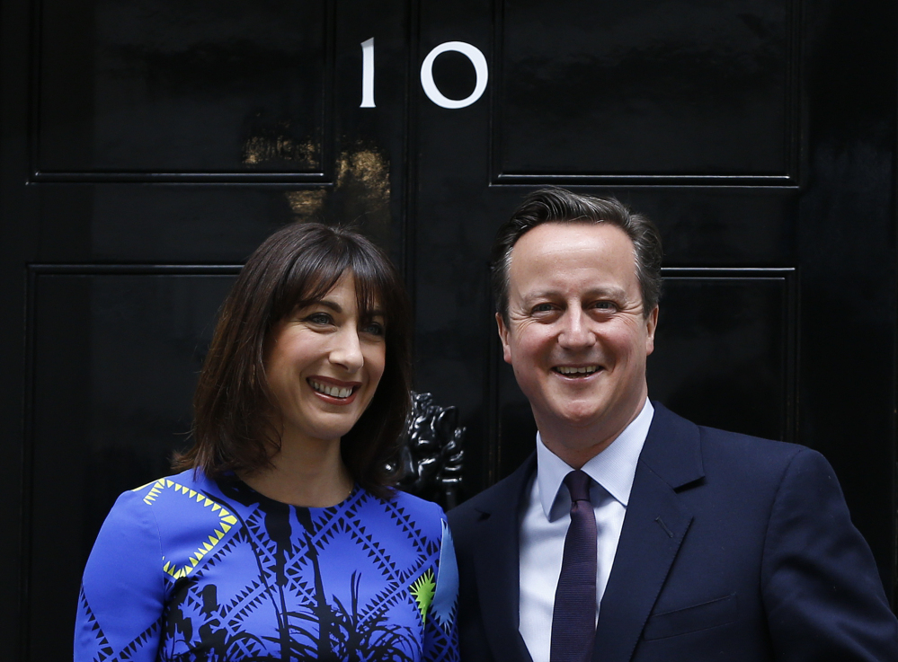 Britain’s Prime Minister David Cameron and his wife, Samantha, pose on the steps of 10 Downing St. in London on Friday after meeting with Queen Elizabeth II. The Conservative Party won an unexpected majority.
