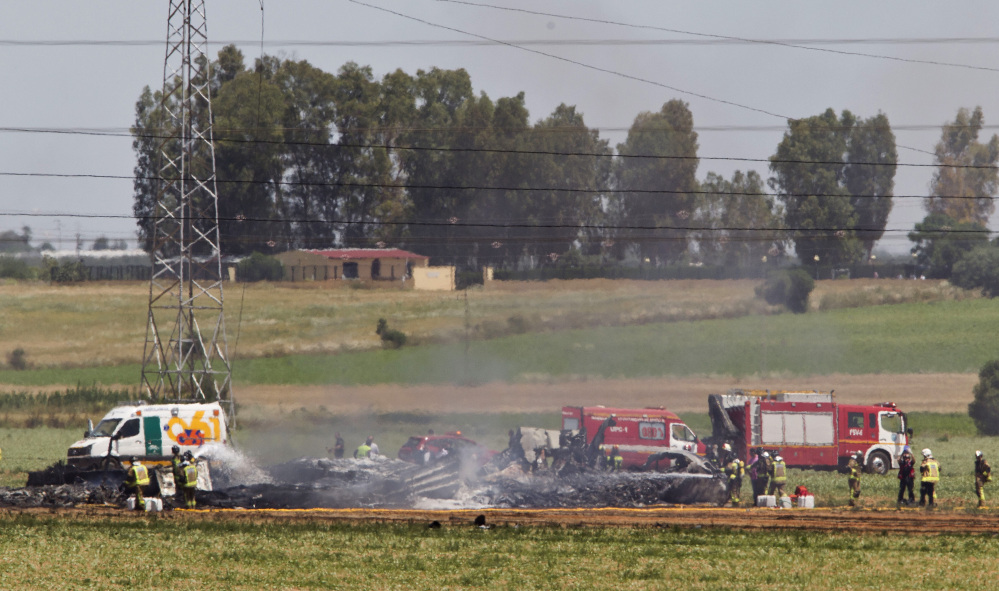 Emergency services personnel work in the area after a plane crash near the Seville airport, in Spain, on Saturday. A military transport plane crashed near southwestern Seville airport, killing four crew members.