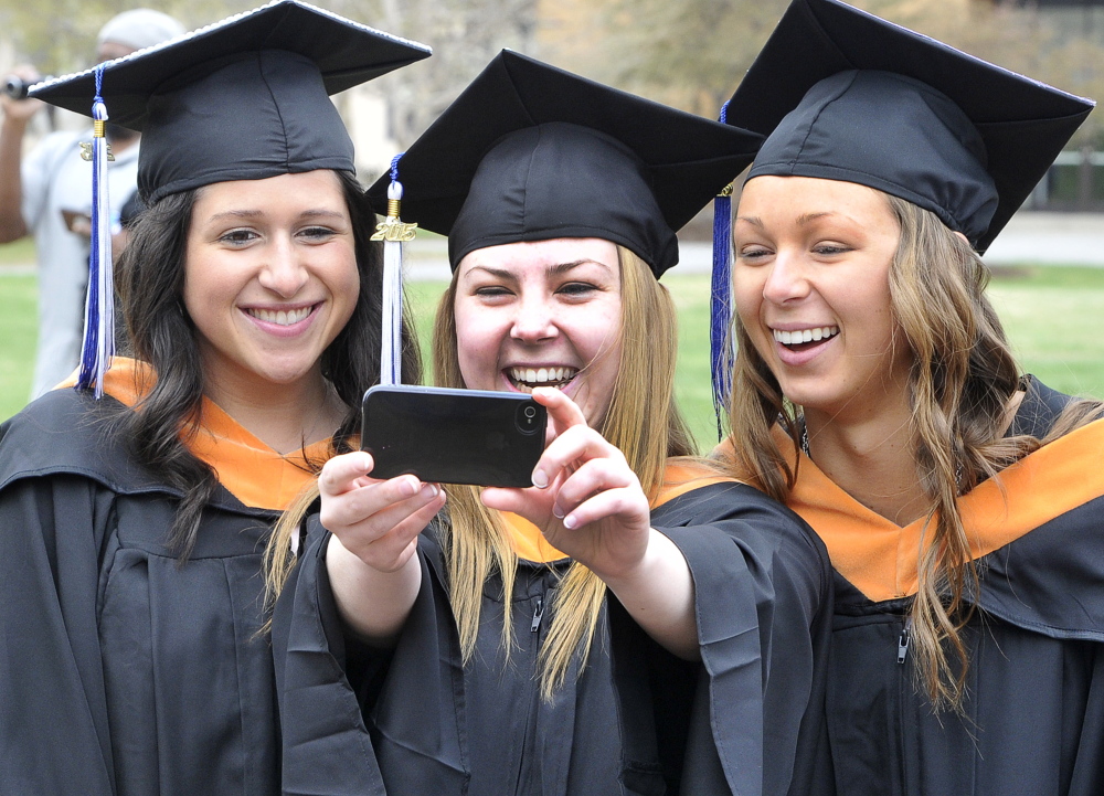 Brooke O’Connor from Lakeville, Mass., center, takes a selfie with Jenna Posey, left, from Scarborough and Jessica Santon from Berkley, Mass., before their graduation at St. Joseph’s College in Standish on Saturday.