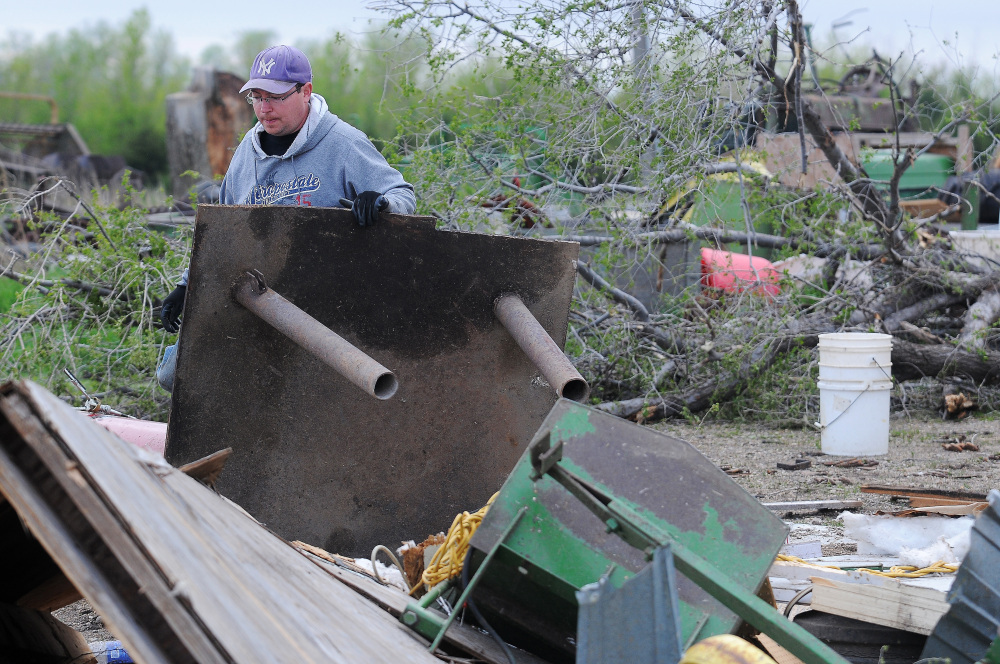 James Fink surveys the damage to family friend Mike Fechner’s farm on Sunday near Delmont, S.D., after a tornado tore through the area damaging homes and businesses.