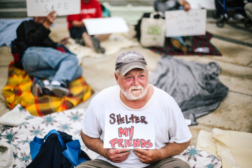Mark Parent, who is homeless, holds a sign outside Portland City Hall on Tuesday.
Whitney Hayward/Staff Photographer