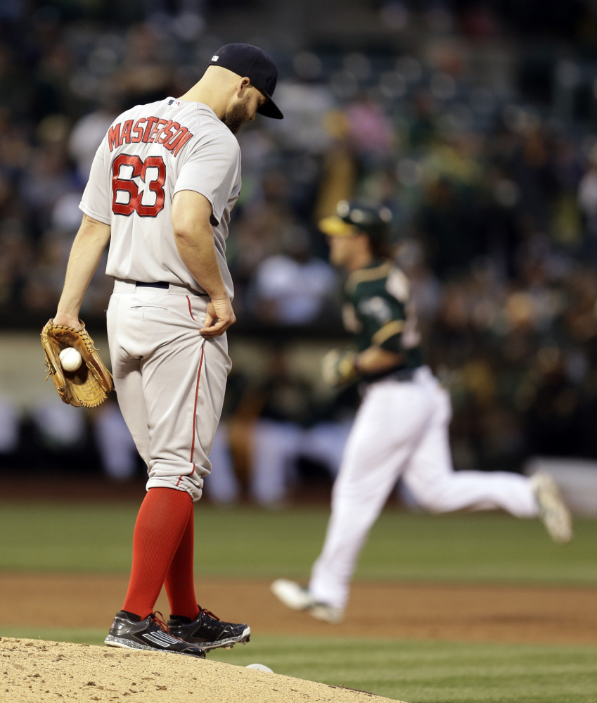 Red Sox pitcher Justin Masterson walks back to the mound after giving up a home run to the Oakland Athletics’ Josh Reddick, running the bases, in the third inning Tuesday night in Oakland.