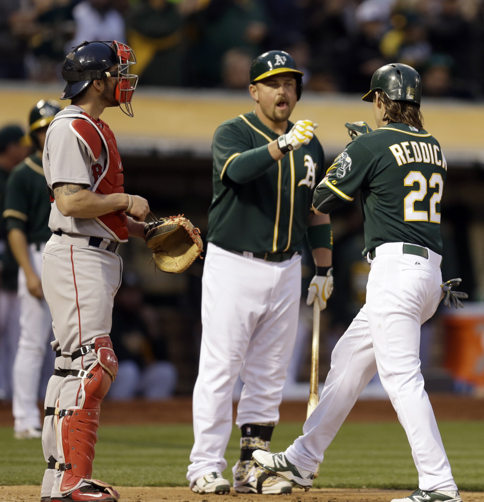 Oakland’s Josh Reddick celebrates with Billy Butler after Reddick’s home run off Red Sox starter Justin Masterson.