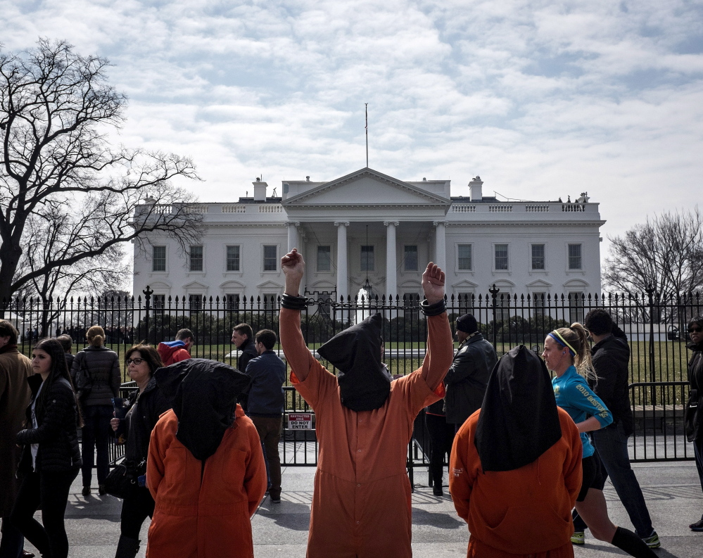 People dressed as Guantanamo Bay prisoners demonstrate in March. Sen. John McCain says he asked the White House for a plan to close the prison in 2009 but didn’t get one.