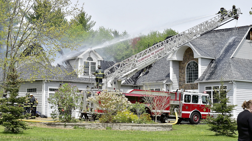 Firefighters from Scarborough and surrounding communities battle a house fire at 2 Beaver Brook Road in Scarborough on Friday.