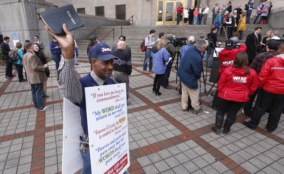 James Dansby protests in front of the courthouse in Birmingham, Ala., as same-sex couples wait for the doors to open so they can be legally married in February. The same-sex marriage issue has brought evangelicals and Catholics closer.