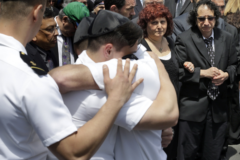 Howard and Susan Zemser, right, watch Friday as midshipmen embrace during the funeral service for their son, U.S. Naval Academy midshipman Justin Zemser, at Boulevard-Riverside-Hewlett Chapel in Hewlett, N.Y. The sophomore, 20, was traveling to his home in New York City when he was killed in Tuesday’s derailment in Philadelphia.
