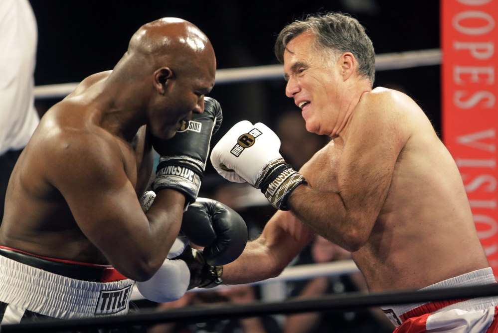 Romney, right, throws punches at Holyfield before ending the fight after just two rounds.