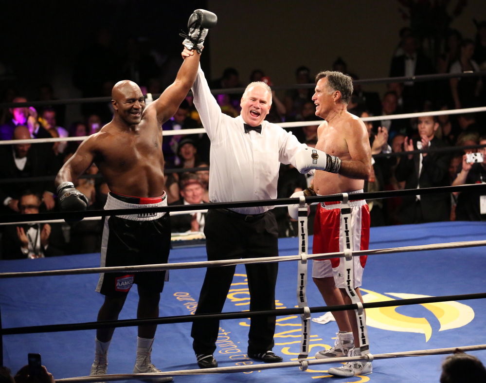 Five-time heavyweight boxing champion Evander Holyfield, left, is declared the winner against Former Republican presidential candidate Mitt Romney during a charity fight night event Friday.