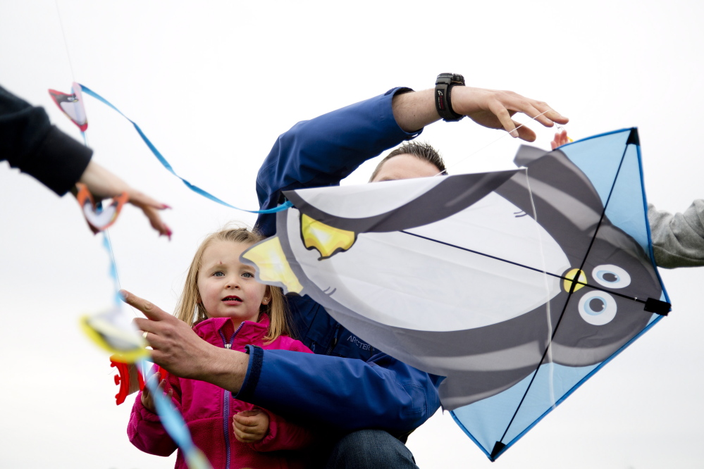 Reese Bethel, 3, of Falmouth looks as her father, George, tries to untangle her kite’s line from those of a few other kites during the Bug Light Kite Festival on Saturday.