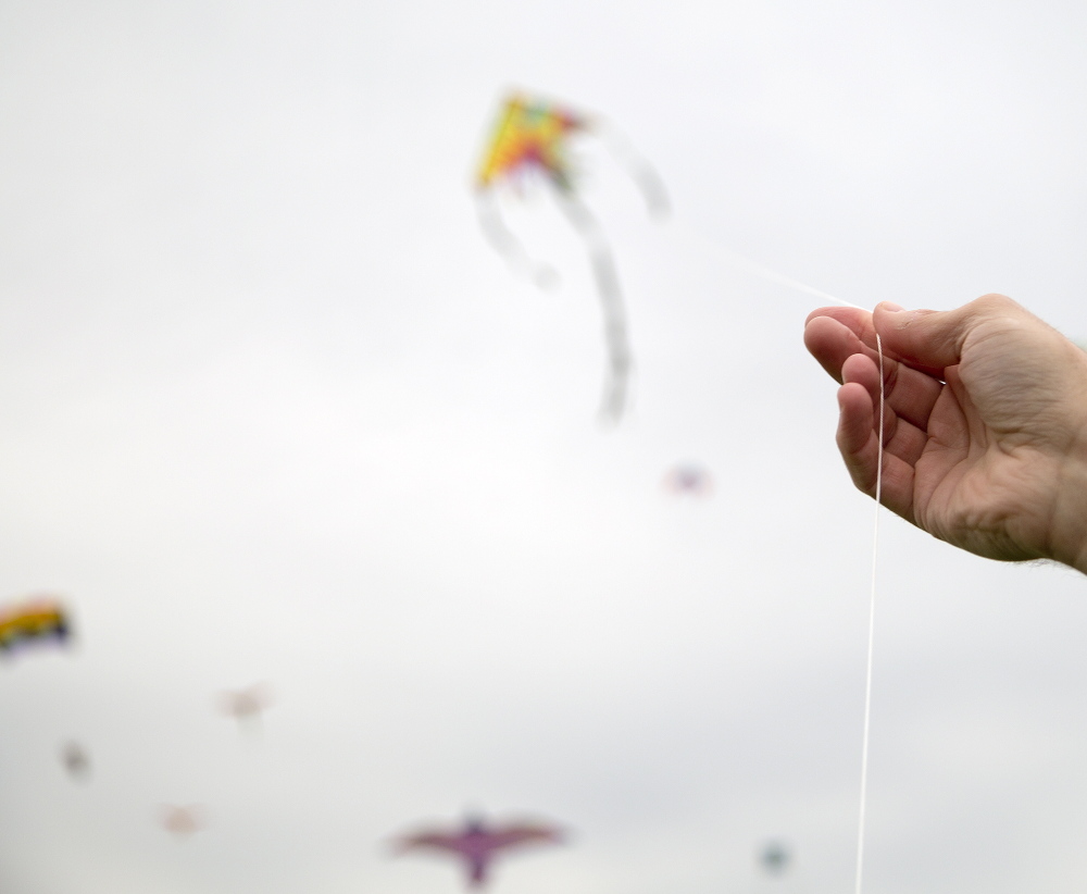 Brendan Bernard of Cumberland holds the string to his son Henry’s kite during the 6th annual Bug Light Kite Festival on Saturday.