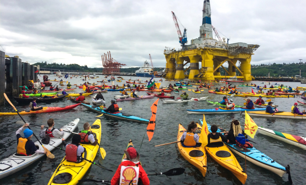 Activists who oppose Royal Dutch Shell’s plans to drill for oil in the Arctic Ocean surround Shell’s Polar Pioneer drilling rig during the “Paddle in Seattle” protest Saturday.