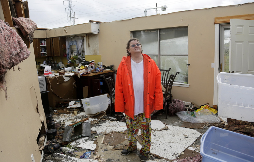 Carol Cole stands in her home in Broken Arrow, Okla., on Sunday after a powerful storm hit the area Saturday night.