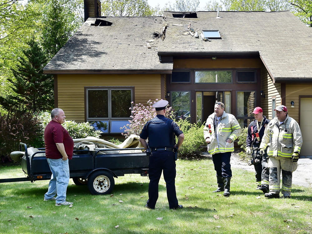 Jr.FALMOUTH, ME - MAY 18: House fire follow-up inspection at 1 Victoria Lane. Owner Sean Crothers, left, standing with Falmouth Police Officer Sgt. Kevin Conger awaits the finding of the cause of the fire that destroyed a part of his house as part of the team of inspectors, Falmouth Fire Chief Howard Rice, Jr., left, Falmouth Fire Department Lt. Zach Tooker, and Deputy Chief Tom Martelle leave the home during the inspection. (Photo by Gordon Chibroski/Staff Photographer)