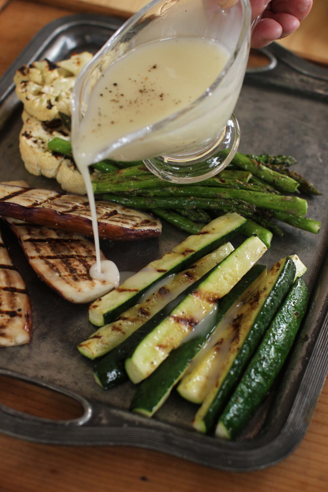Grilled pork chops and asparagus with lemon-truffle vinaigrette. The Associated Press