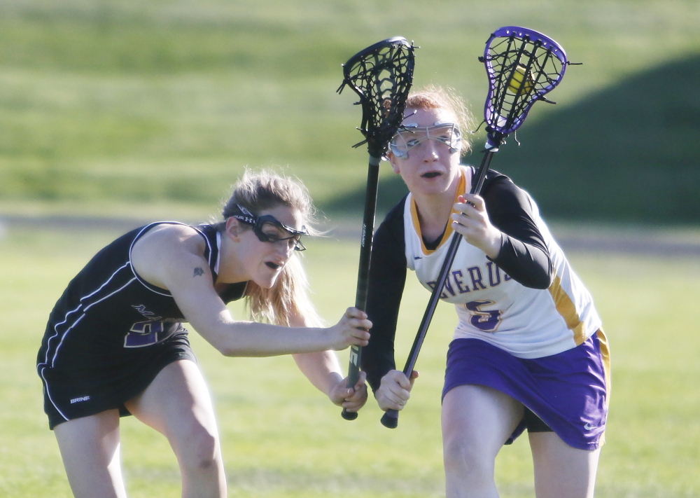 Emily Duff of Cheverus, right, keeps her eyes on the ball Thursday while pressured by Claudia Folger of Marshwood during their schoolgirl lacrosse game in Portland. Marshwood came away with a 14-2 victory.