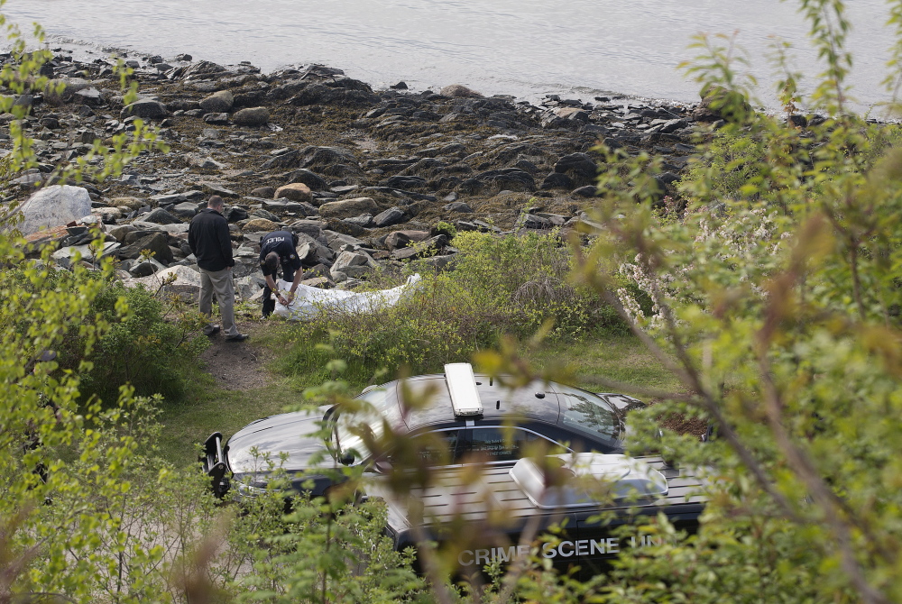 Police investigate the scene where a woman’s body was found on the Portland shore near Fort Allen Park on Friday.