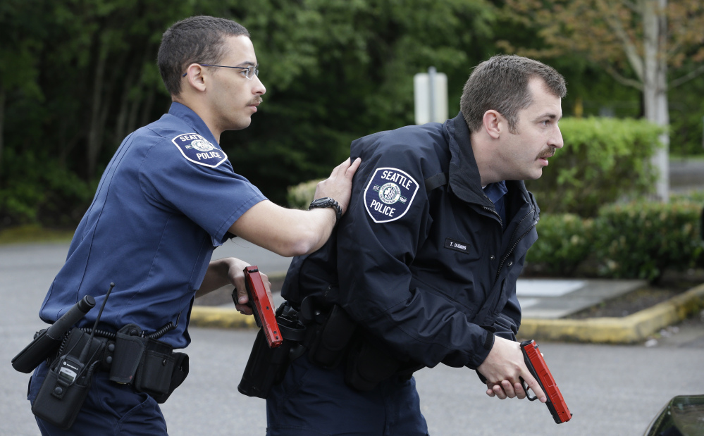 Seattle police recruits Tre Smith, left, and Travis Duennes work together in a practice scenario at the Washington State Criminal Justice Training Commission in Burien.