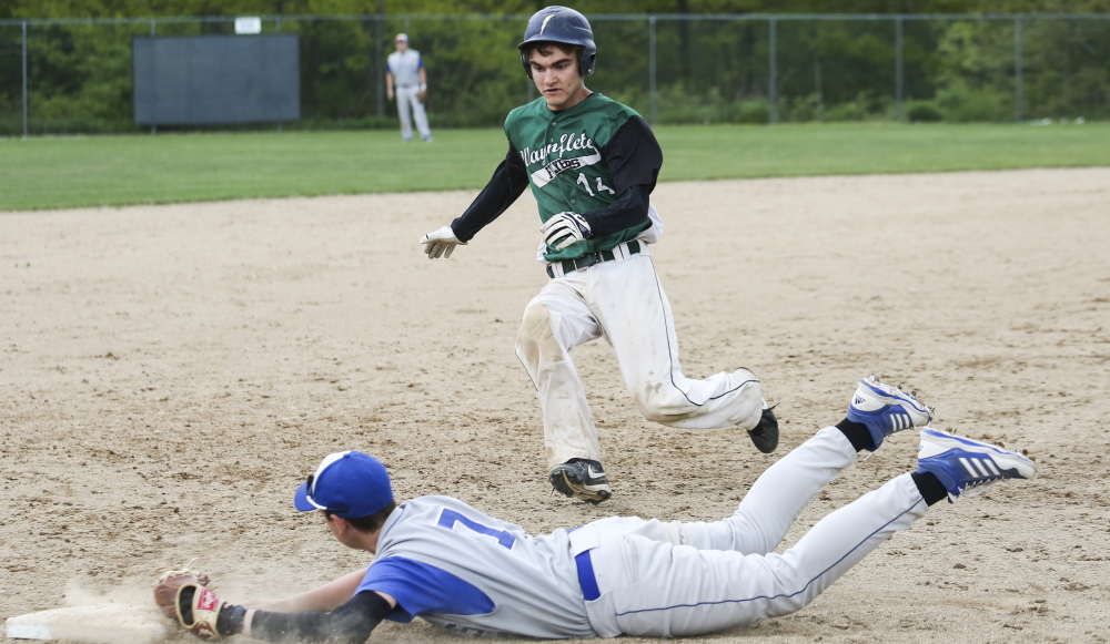 Third baseman Brian Davis of Old Orchard Beach dives for the bag and records the out Friday as Jacob Hagler of Waynflete begins his slide during Old Orchard’s 17-4 victory at Fore River Field in Portland.
