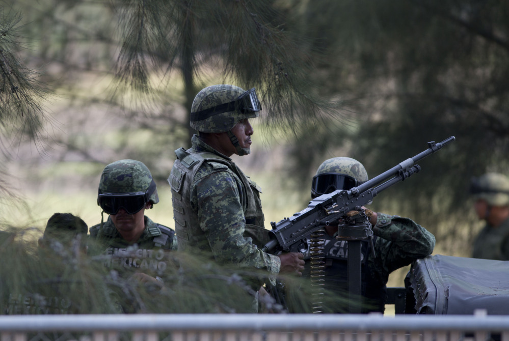 Mexican Army soldiers stand guard near the entrance of Rancho del Sol, near Ecuanduero, in western Mexico.
