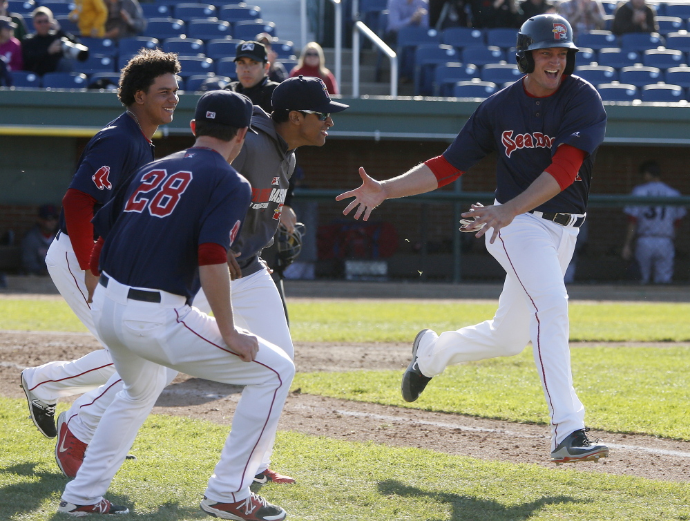 Jonathan Roof celebrates with his Sea Dogs teammates as he scores the winning run Saturday in Game 2 of a doubleheader against the Reading Fightin Phils at Hadlock Field. Portland won 2-1, salvaging a split after a 3-2 defeat in Game 1.