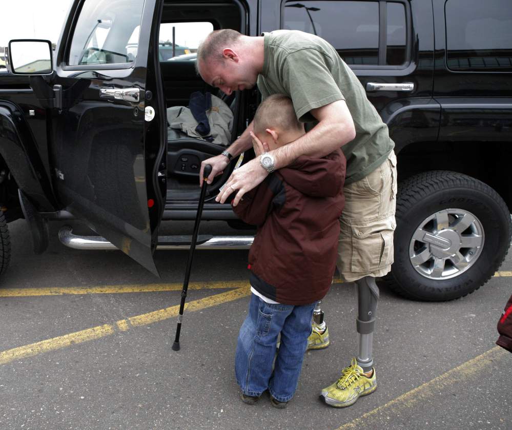 In this 2008 photo, retired Minnesota National Guard Sgt. John Kriesel comforts his son. Kriesel lost both his legs when a roadside bomb went off near Fallujah, Iraq, in 2006.