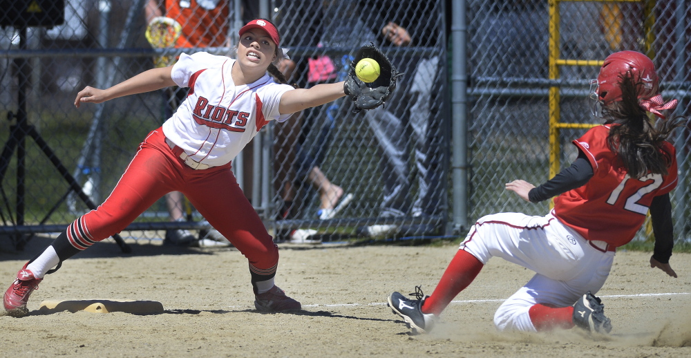 Laurine German of South Portland stretches for a throw as Scarborough’s Hannah Ricker slides safely into third base during their SMAA softball game Saturday in Scarborough. The hosts improved to 13-0 with a 5-4 victory.