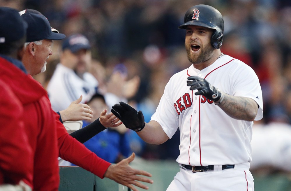 Mike Napoli is welcomed back to the dugout Saturday night after hitting a home run for the Boston Red Sox in the second inning of an 8-3 victory against the Los Angeles Angels. Napoli homered twice.