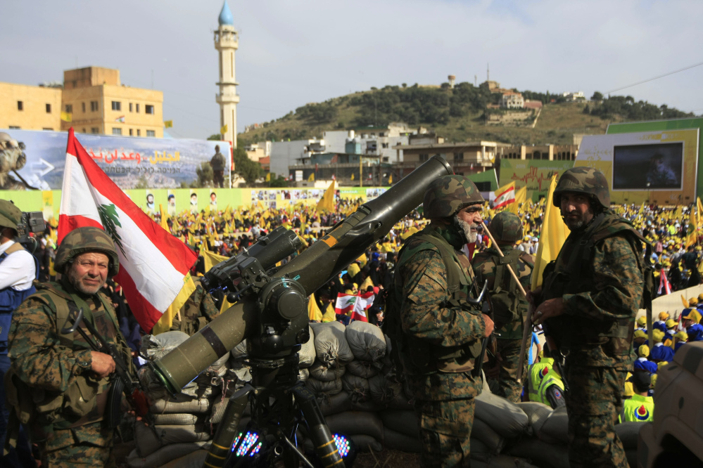 Hezbollah fighters stand guard during a rally Sunday in Nabatiyeh, Lebanon, celebrating the country’s Liberation Day. The leader of Hezbollah said his militants will expand their support of government forces in the Syrian civil war.
