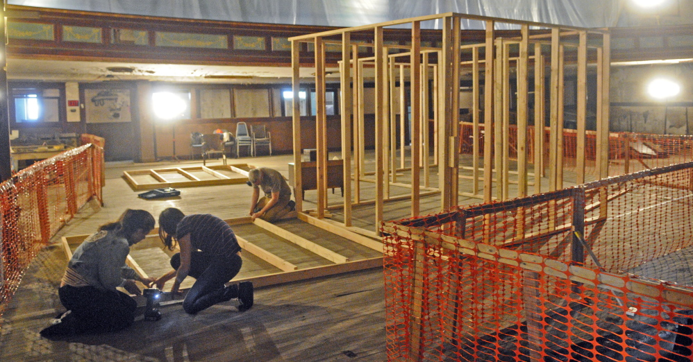 Kelly Rioux, left, Caroline Losneck and Chris Byron built a frame for a house that will be part of an art installation next month at the Colonial Theater in Augusta.