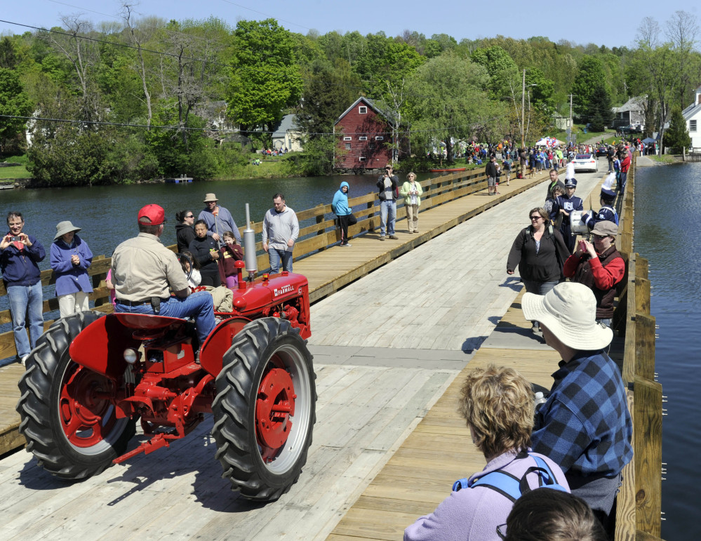 A tractor is driven across the floating bridge during a reopening parade in Brookfield, Vt., on Saturday. The bridge is believed to be the only one of its kind in the country.