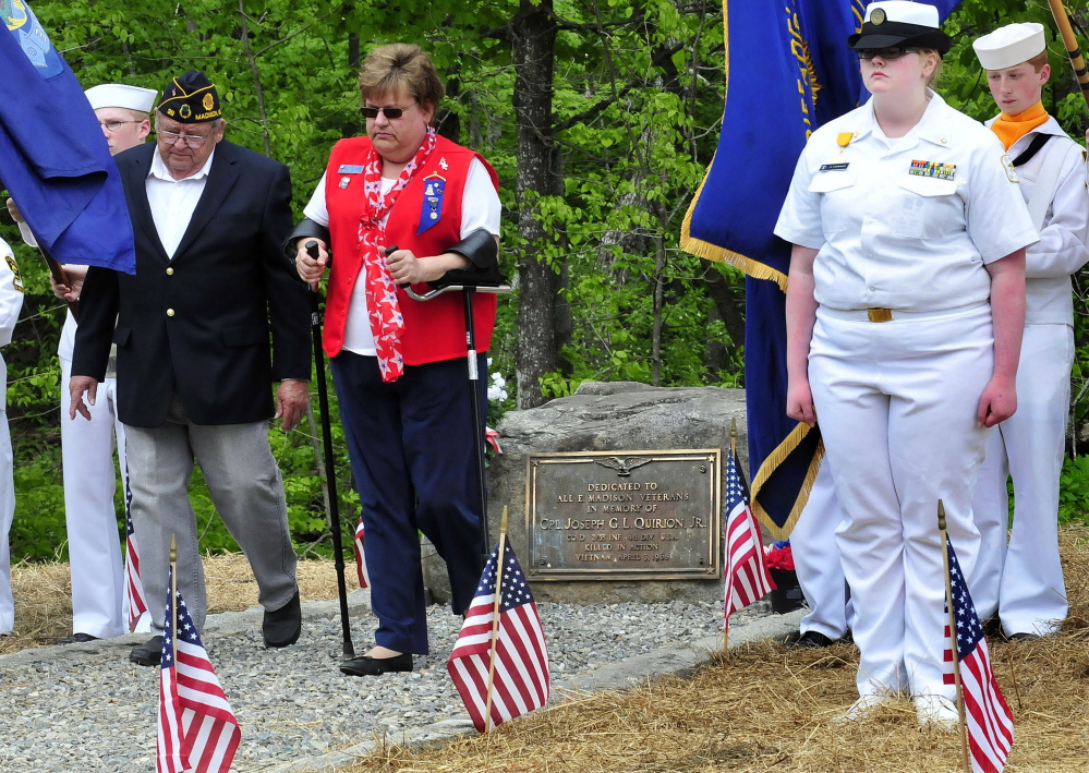 Earl Beaulieu and Robin Turek walk away after placing a wreath at the veterans’ memorial in East Madison.