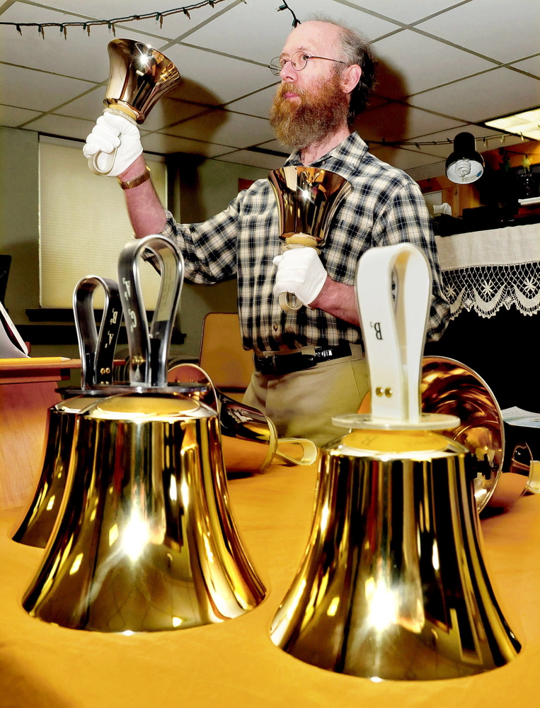Jon Loekle rings the large bass bells during a practice with other members of the Over the River Ringers handbell group recently.