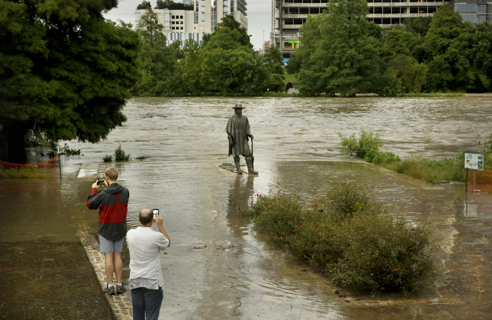 Water levels reach the base of a well-known statue of Stevie Ray Vaughan along the banks of Lady Bird Lake in Austin, Texas, Monday.