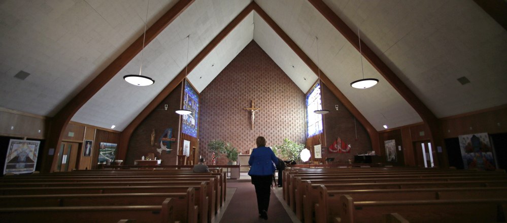 Maryellen Rogers walks down the center aisle of the St. Frances Xavier Cabrini Roman  Catholic Church in Scituate, Mass., on May 20. Parishioners have occupied the church, night and day, for almost 11 years, hoping the Boston archdiocese will restore their parish’s standing or sell them the building outright.