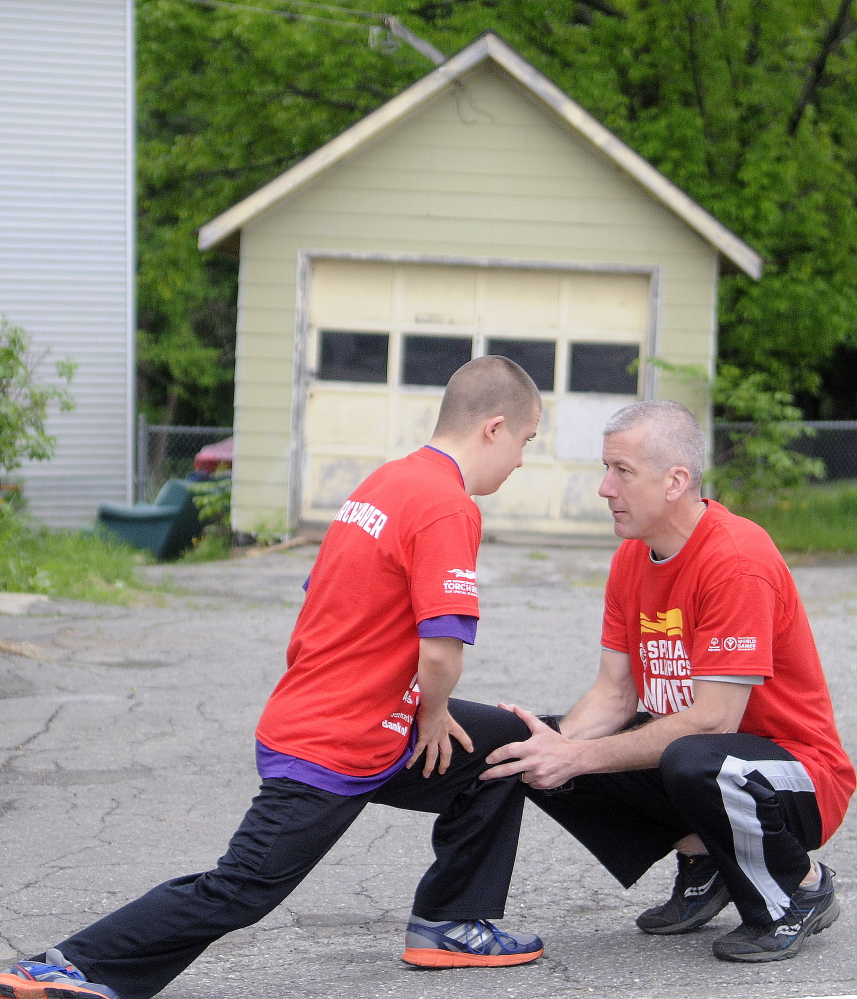 Special Olympian Zach Ewing stretches with his father, Orono Police Chief Josh Ewing, before running in the first leg of the Special Olympics Unified Relay Across America Torch Run in Augusta on Tuesday.