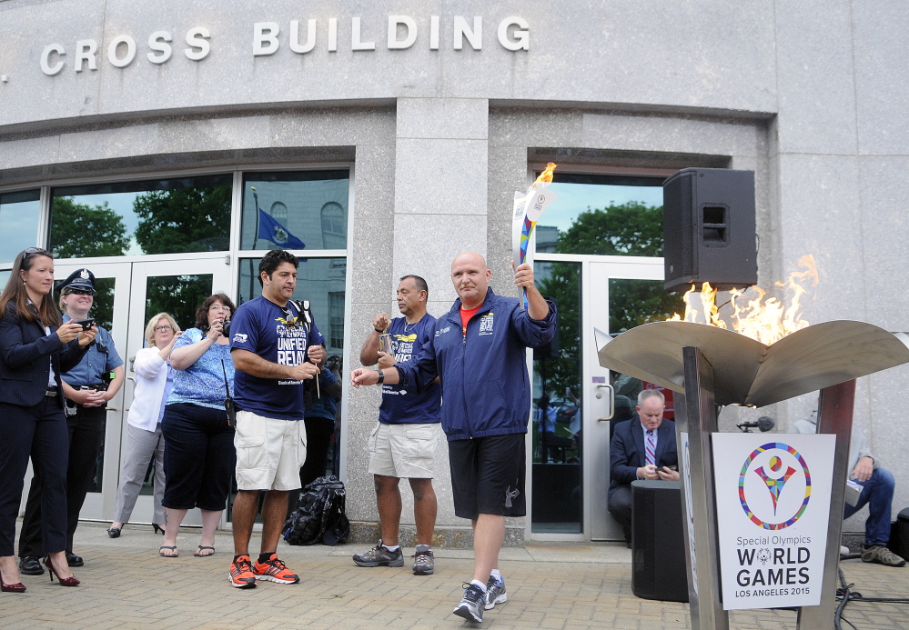 A torch is lit Tuesday outside the State House in Augusta for the first leg of the Special Olympics Unified Relay Across America Torch Run.
