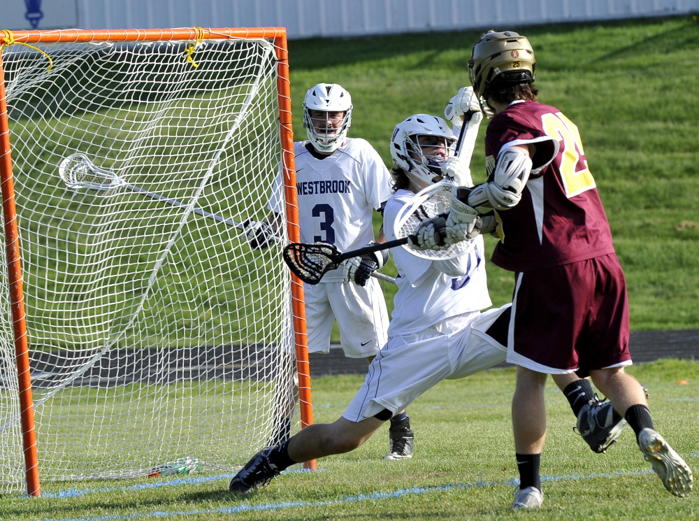Justin Masteller of Thornton Academy gets the ball past Westbrook goalkeeper Alex Leblanc during their boys’ lacrosse game Wednesday at Westbrook High. Thornton used four goals in a three-minute span to come away with a 14-10 victory.